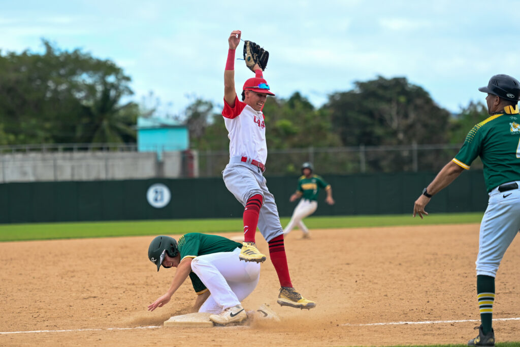 un lanzamiento salvaje le da la llegada a uno de los peloteros de la uipr a salvo en tercera base.jpg (l. minguela lai)