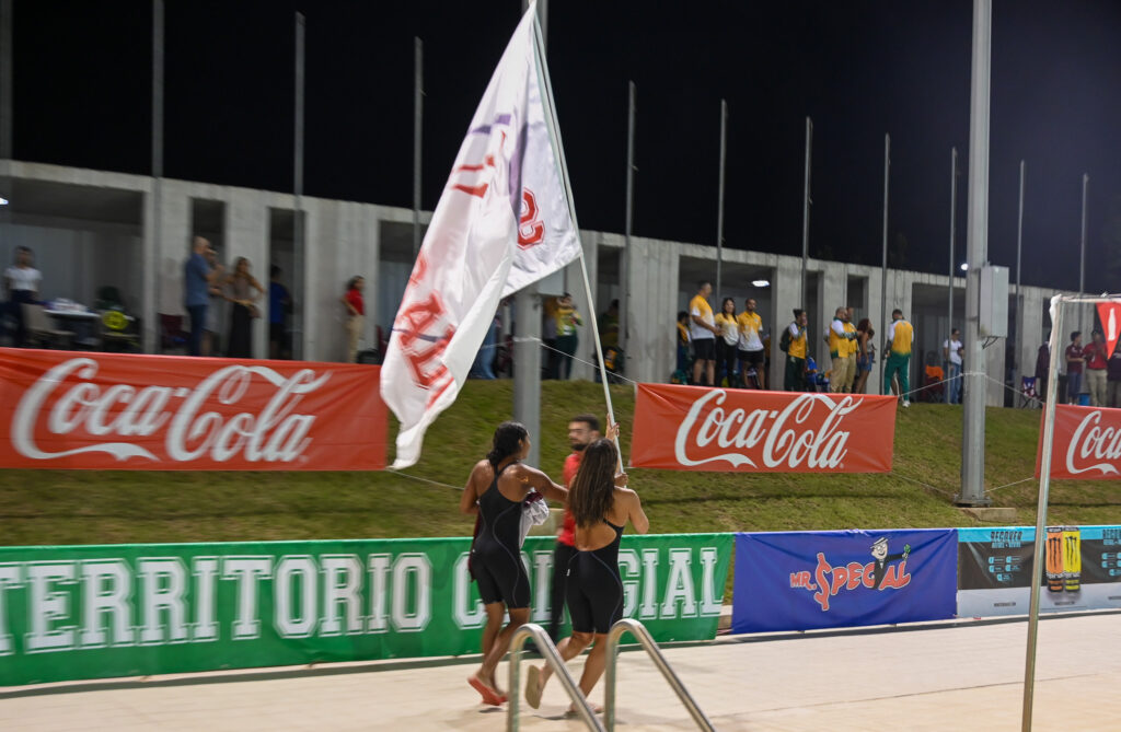 dos atletas de sagrado corren con la bandera de la institución que lleva 145 años aportando a la sociedad puertorriqueña.jpg (luis f. minguela lai)