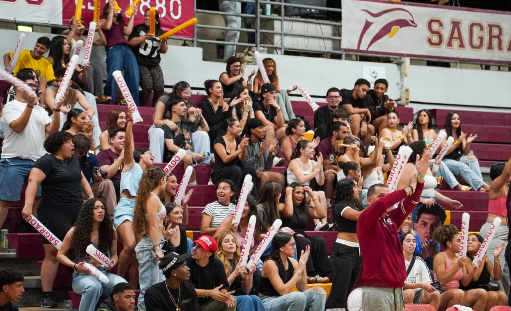 en la extrema derecha guayito santriago dando instrucciones, mientras la fanatica apoya a los delfines durante el partido.jpg (roberto j. rivera guzmán para la lai)