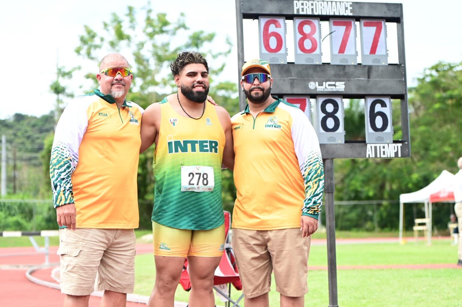 tres tigres felices. michael soler con sus entrenadores posando al lado de la nueva marca de la lai en lanzamiento de martillo.jpeg (jorge colón lai)